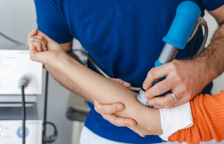 Stoßwellentherapie in München bei einem Münchner Orthopäden im blauen Hemd, in einer Privatpraxis namens Ortho Lehel.